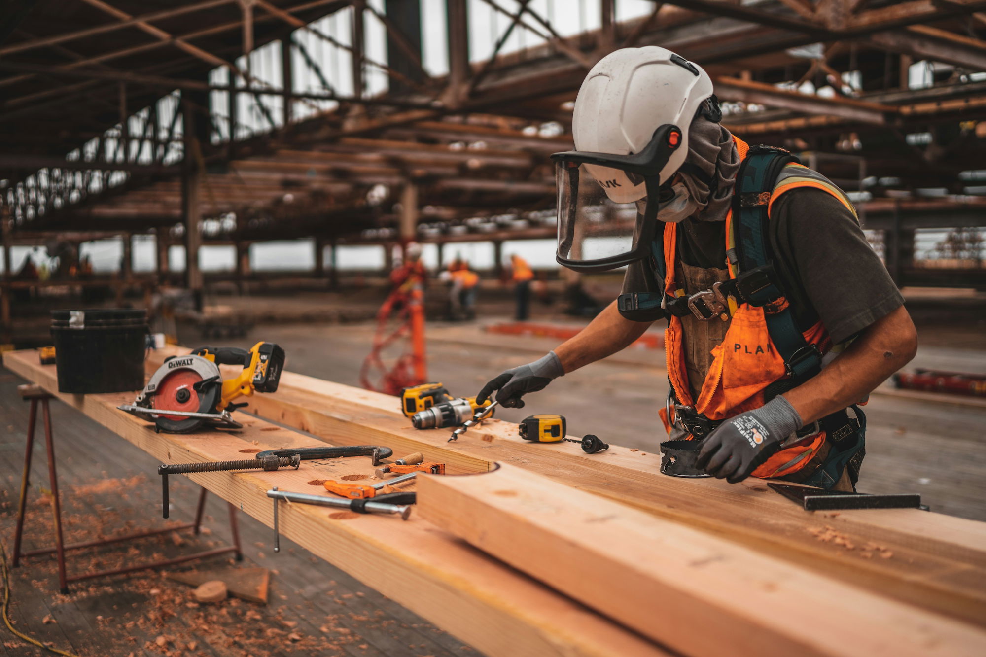 man-in-orange-and-black-vest-wearing-white-helmet-holding-yellow-and-black-power-tool.jpg man in orange and black vest wearing white helmet holding yellow and black power tool